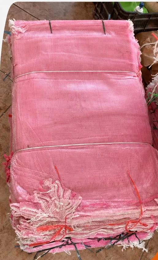 Paca de arpillas rosas circulares con jareta, listas para la empacadora de cebolla